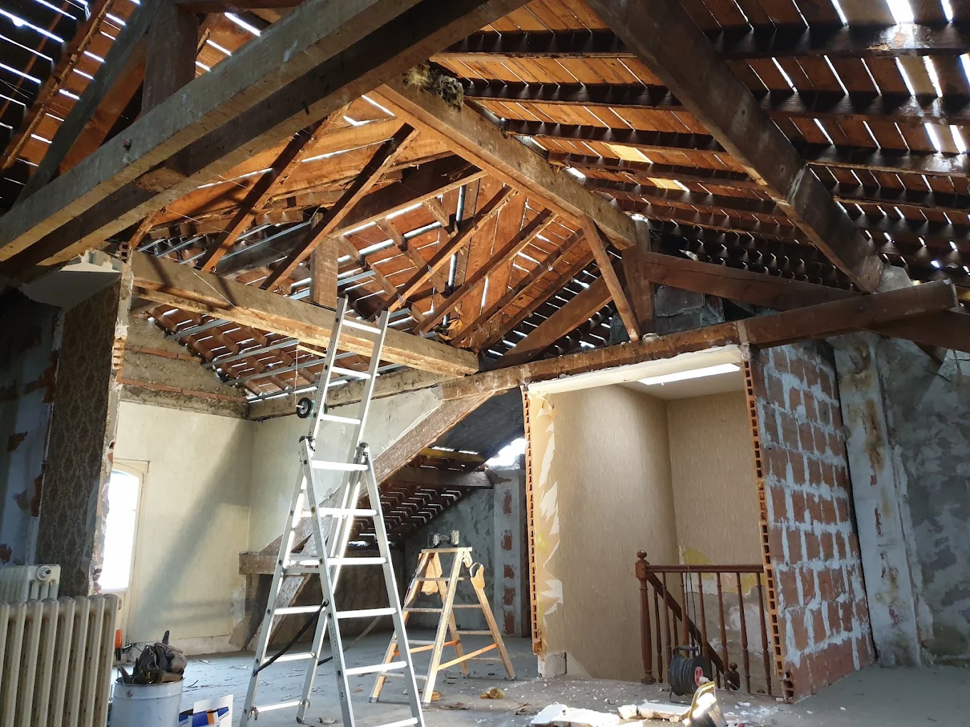Combles avant travaux : charpente et maçonnerie apparentes