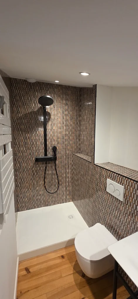 Salle d'eau terminée avec douche à l'italienne et mur en carrelage